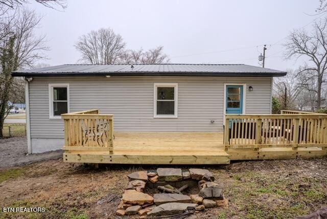 rear view of property with metal roof and a deck