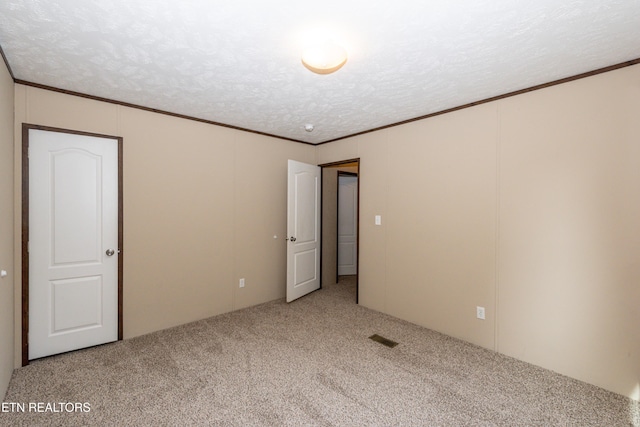 unfurnished bedroom with carpet, crown molding, and a textured ceiling