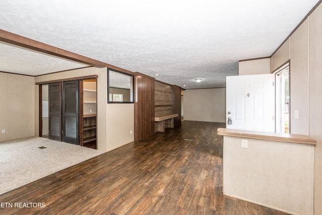 spare room with a textured ceiling, crown molding, and dark hardwood / wood-style flooring