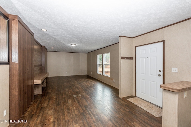 foyer entrance featuring dark hardwood / wood-style flooring, a textured ceiling, and ornamental molding