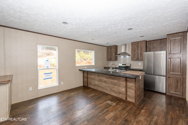 kitchen with stainless steel appliances, sink, ornamental molding, wall chimney range hood, and dark hardwood / wood-style floors