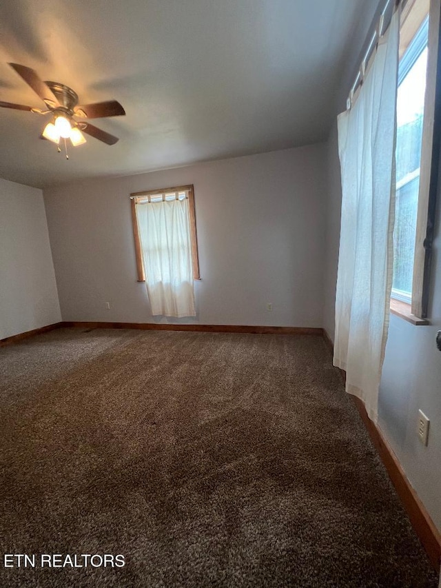 carpeted spare room featuring baseboards and ceiling fan