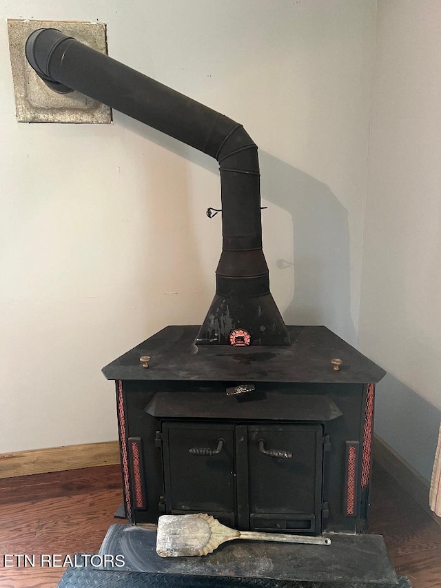interior details featuring wood finished floors and a wood stove