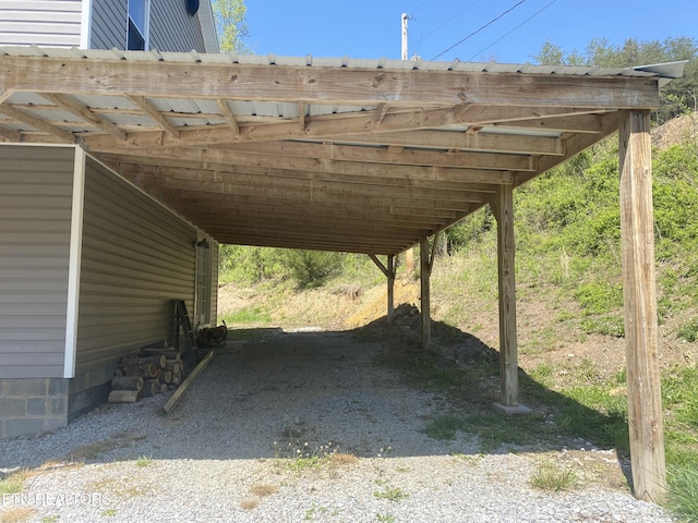 view of vehicle parking featuring gravel driveway and a carport