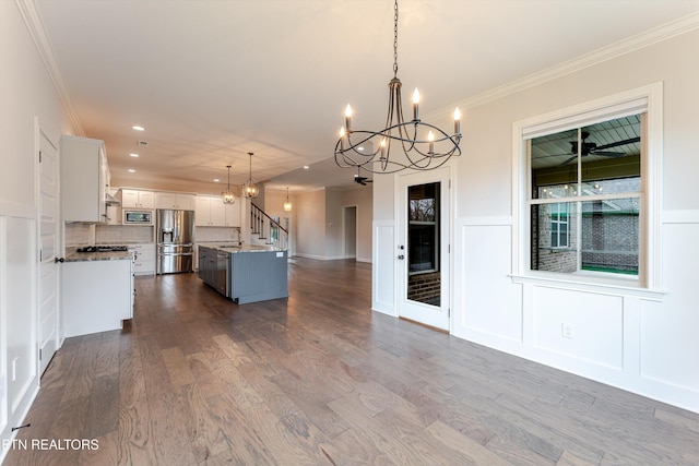 282 Chimney Rock Dr, Lenoir City, TN 37771 - kitchen with a decorative wall, ornamental molding, appliances with stainless steel finishes, open floor plan, and a notable chandelier