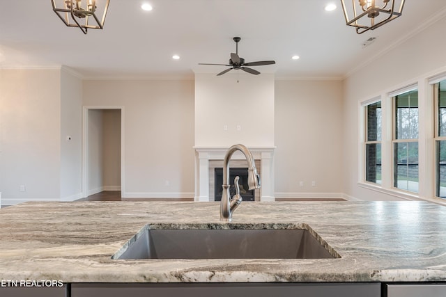 282 Chimney Rock Dr, Lenoir City, TN 37771 - kitchen with open floor plan, a sink, crown molding, and light stone countertops
