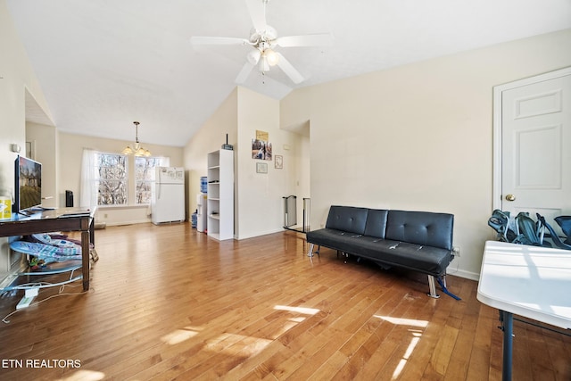 living area featuring lofted ceiling, baseboards, hardwood / wood-style floors, and ceiling fan with notable chandelier