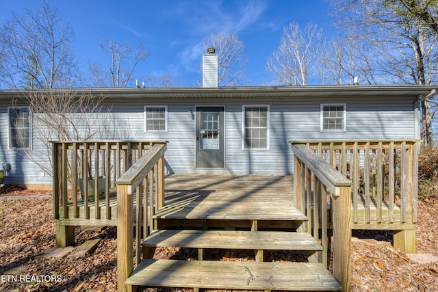 rear view of property with a deck and a chimney