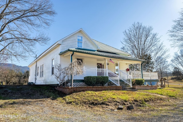 farmhouse-style home featuring a porch and metal roof