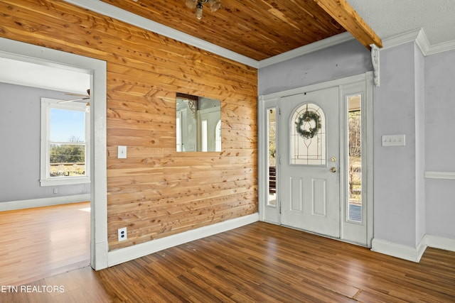 entryway with ornamental molding, wooden walls, baseboards, and wood finished floors