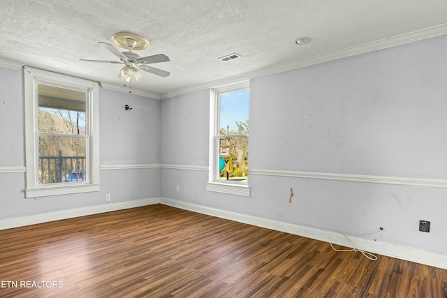 unfurnished room with crown molding, dark wood-style flooring, visible vents, and plenty of natural light