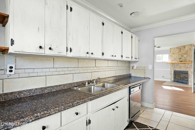 kitchen featuring dishwasher, ornamental molding, a sink, and white cabinetry