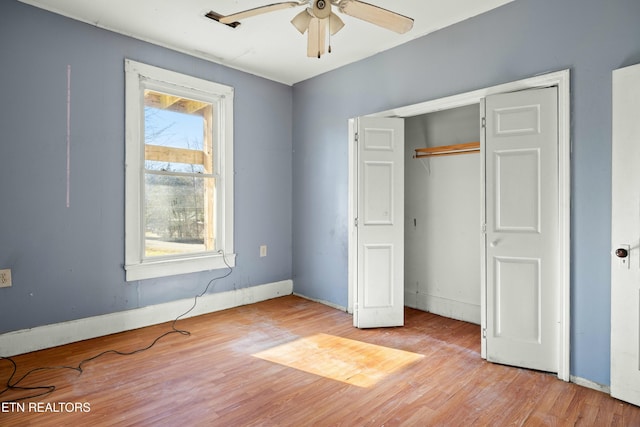 unfurnished bedroom with a closet, light wood-style flooring, and baseboards