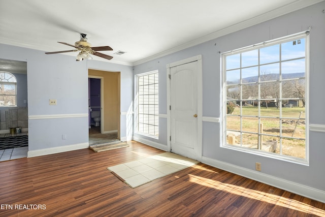 entrance foyer with baseboards, wood finished floors, a mountain view, and crown molding