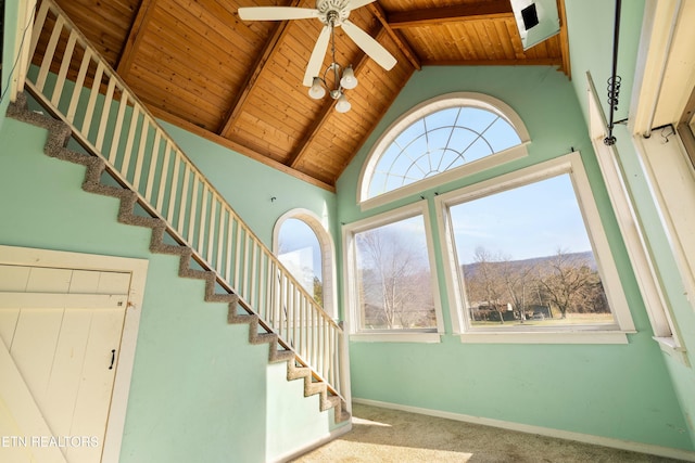 stairs with baseboards, wooden ceiling, beamed ceiling, carpet flooring, and high vaulted ceiling