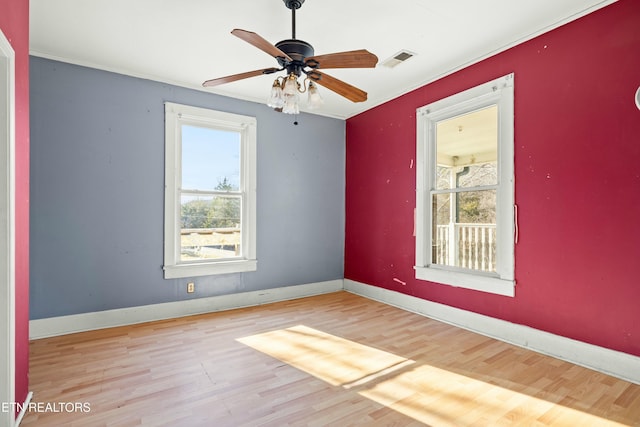 empty room featuring light wood-style floors, baseboards, visible vents, and ceiling fan