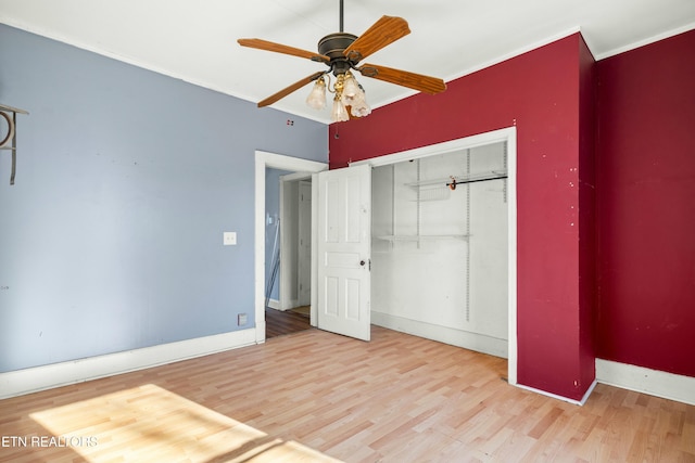 unfurnished bedroom featuring ornamental molding, a closet, and light wood-style flooring