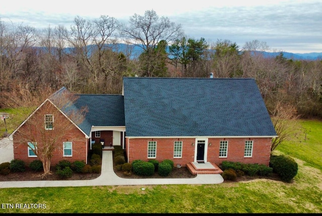 view of front of house with brick siding and a front lawn