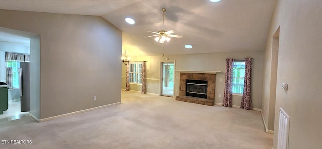 unfurnished living room with light carpet, vaulted ceiling, ceiling fan, and a fireplace