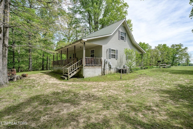 view of front of home featuring stairs, metal roof, a front lawn, and a porch