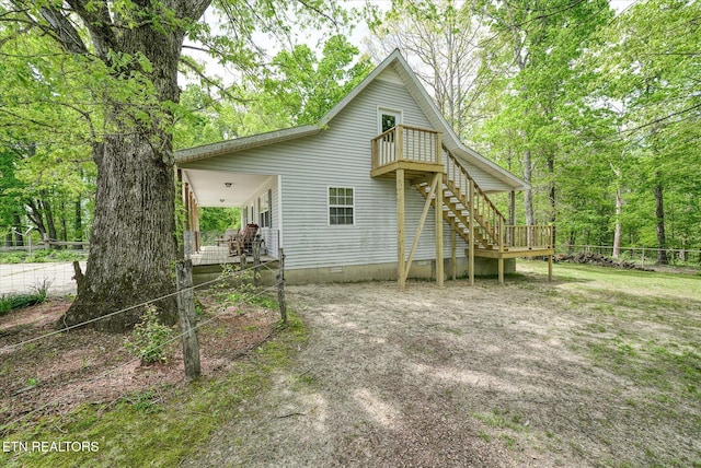 exterior space featuring stairway, crawl space, and fence