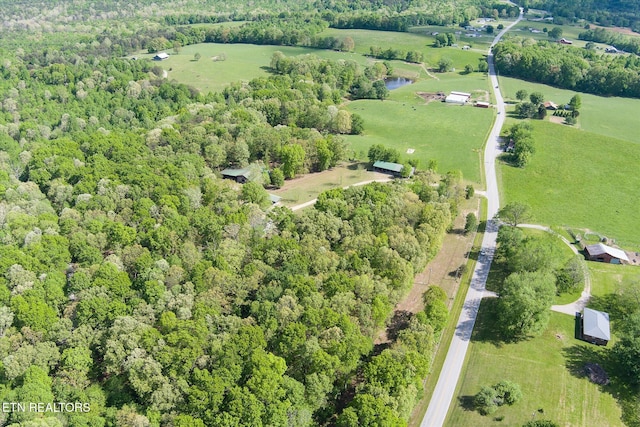 birds eye view of property with a view of trees and a rural view