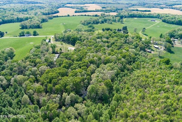 drone / aerial view featuring a view of trees and a rural view