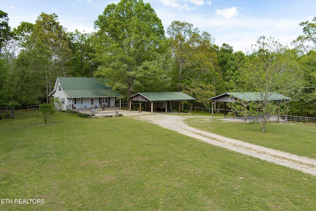 exterior space with a carport, a lawn, driveway, and fence