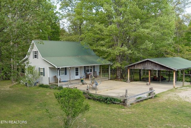 view of front of home with a porch, metal roof, a carport, driveway, and a front lawn