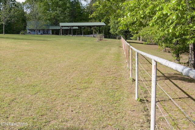 view of yard with fence and a rural view