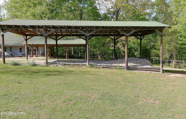 view of property's community featuring a carport, a lawn, and fence