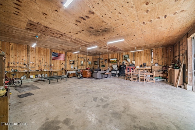 garage featuring wood walls, a workshop area, and wood ceiling