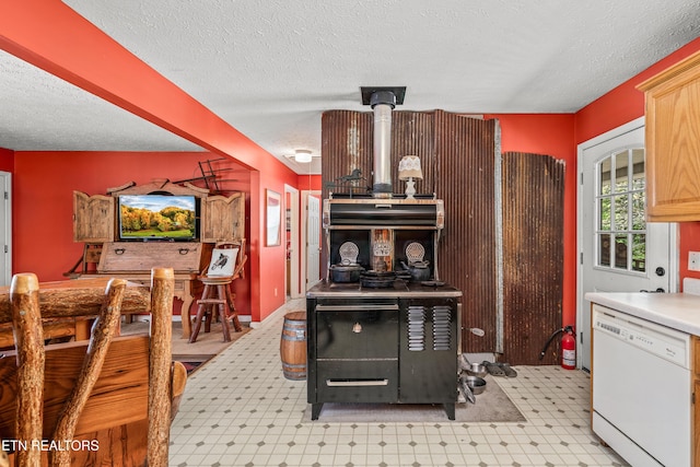 kitchen featuring dishwasher, light brown cabinetry, and a textured ceiling