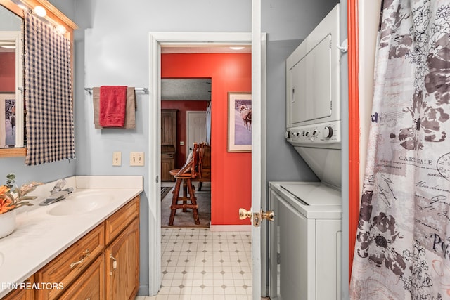 full bathroom featuring stacked washer / drying machine, vanity, and tile patterned floors