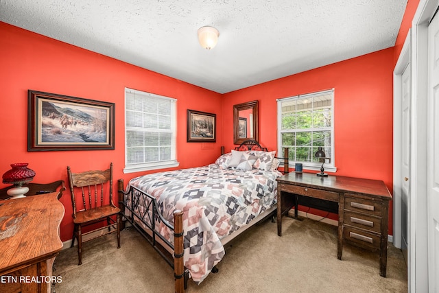 bedroom featuring a textured ceiling, carpet floors, and baseboards