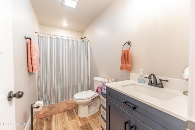 bathroom featuring hardwood / wood-style flooring, vanity, a shower with shower curtain, and toilet