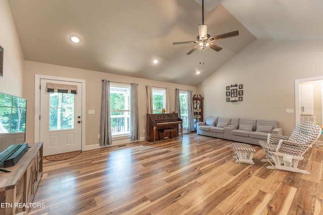 living room featuring ceiling fan, high vaulted ceiling, and light hardwood / wood-style floors