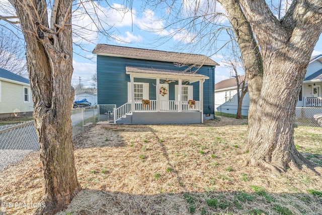 view of front of home with covered porch, fence, and a ceiling fan