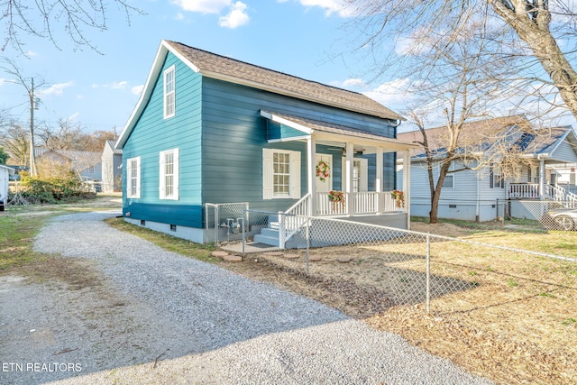 view of front facade with covered porch, driveway, roof with shingles, and fence