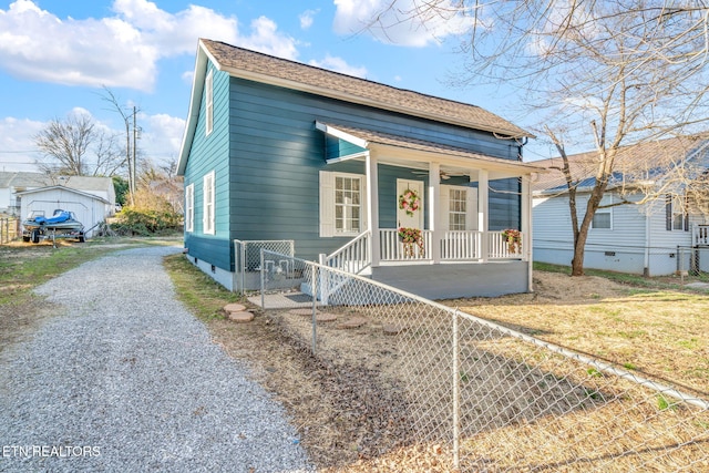 view of front of property with a shingled roof, covered porch, fence, and driveway