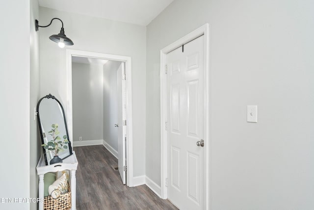 corridor with dark wood-style floors and baseboards