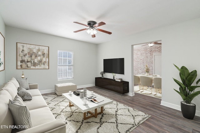 living room with ceiling fan, baseboards, and wood finished floors