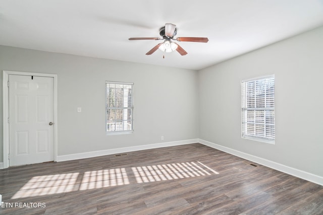 unfurnished room with ceiling fan, wood finished floors, and baseboards