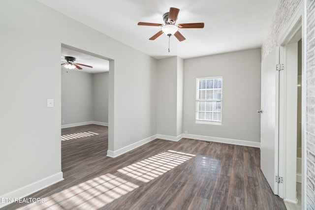 spare room featuring a ceiling fan, baseboards, and wood finished floors