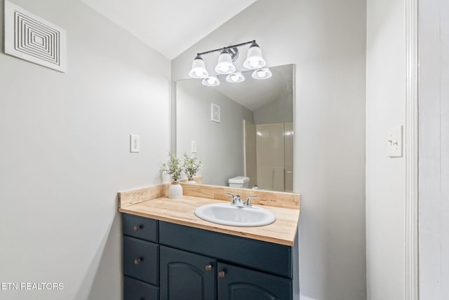 bathroom with lofted ceiling, visible vents, vanity, and toilet