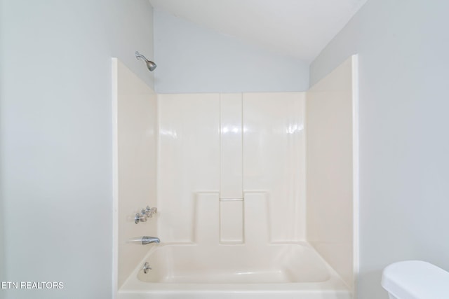 full bath featuring toilet, vaulted ceiling, and shower / bathing tub combination