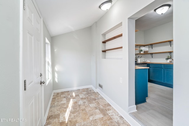 clothes washing area featuring stone finish floor, visible vents, and baseboards