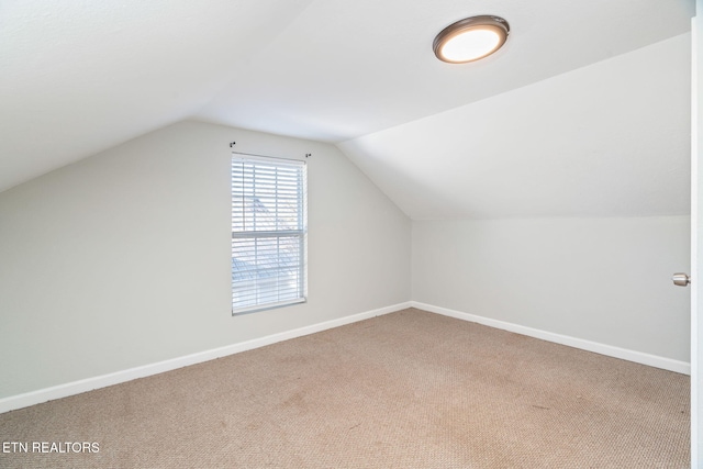 bonus room with lofted ceiling, baseboards, and carpet flooring