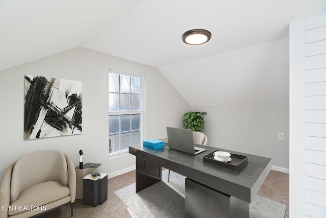 office area featuring lofted ceiling, carpet flooring, and baseboards