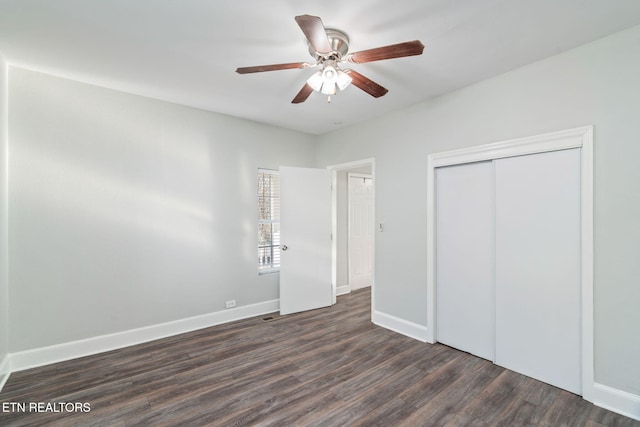 unfurnished bedroom featuring dark wood-style flooring, a closet, a ceiling fan, and baseboards